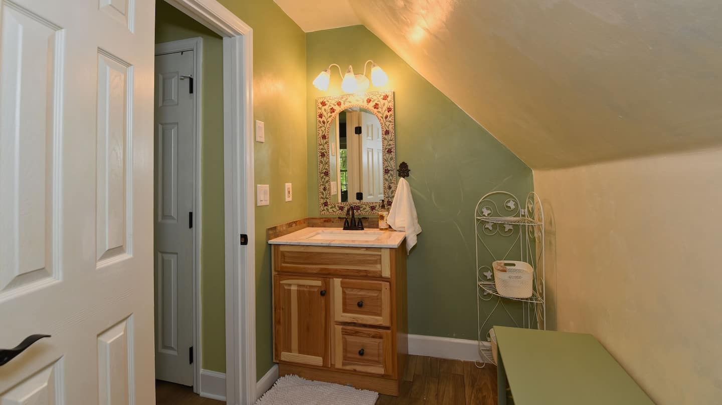 Hawk's Crest Landing I — upper bathroom with floral mirror and sloped ceiling